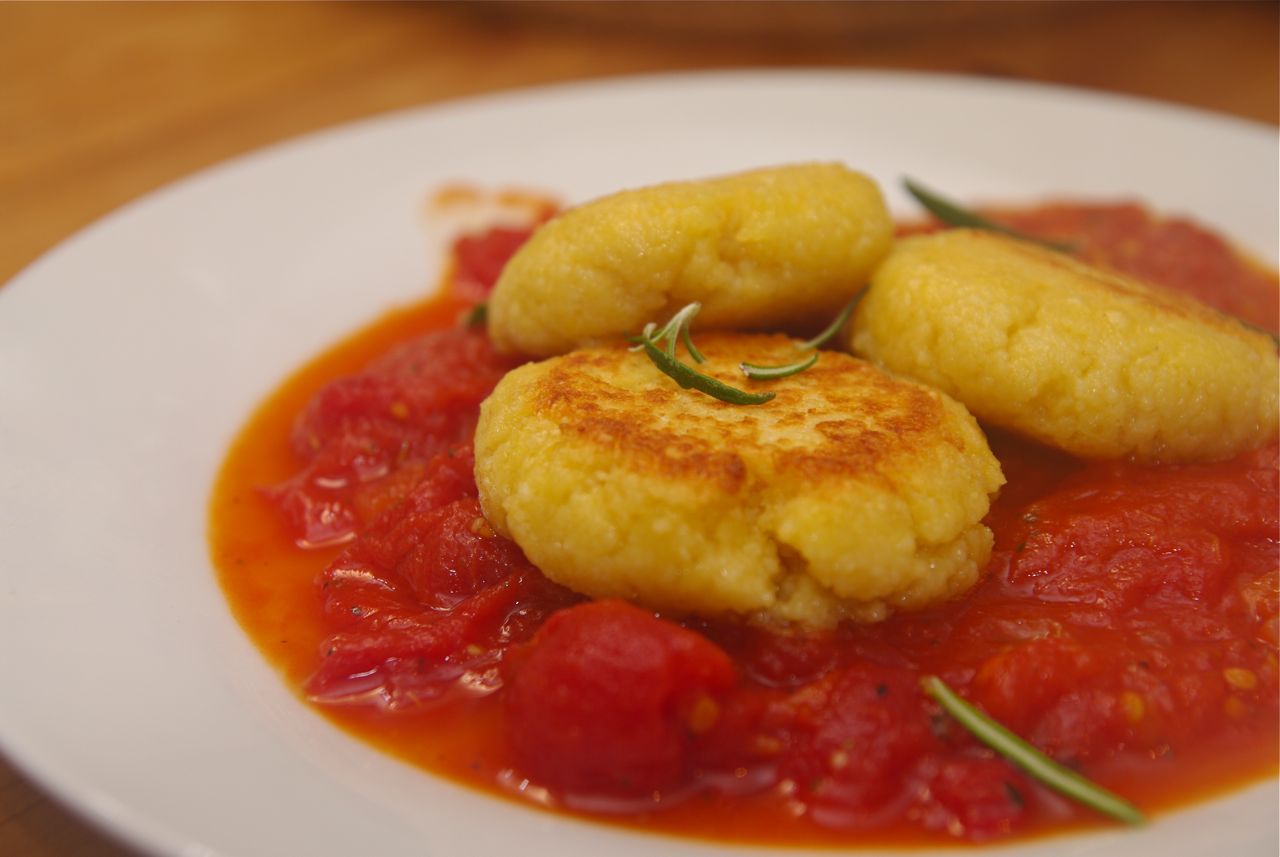 Gebratene Couscous-Käse-Taler auf einer würzigen Tomatensauce ...